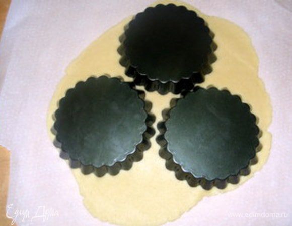 Через час достать тесто.Его лучше раскатывать между двумя листами пергамента. При формочках диаметром 12 см получается 6 корзиночек. Я всегда покрываю дно формочек пергаментом. Бортики формочек смазать сливочным маслом. 