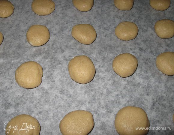 Размягчить сливочное масло, Растереть ложкой масло и сахар, добавить остальные продукты и замесить тесто. Тесто получается похожее на пластилин.Сделать из теста шарики размером с грецкий орех,  выложить их на протвень, накрытый бумагой, не придавливая. 