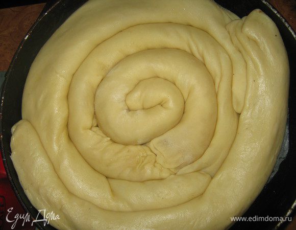 Круглую форму для выпечки застилаем пергаментной бумагой, смазываем её сливочным маслом. Выкладываем рулетики улиткой начиная с серединки. 
Смазываем сверху взбитым яйцом и посыпаем хорошенько сахаром. Выпекаем при температуре 200 градусов минут 40. Приятного аппетита!
