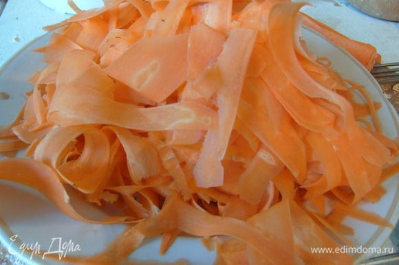 Тем временем карамелизовать сырую морковь. Для этого ее сперва очистить и при помощи овощечистки нарезать на тонкие полоски