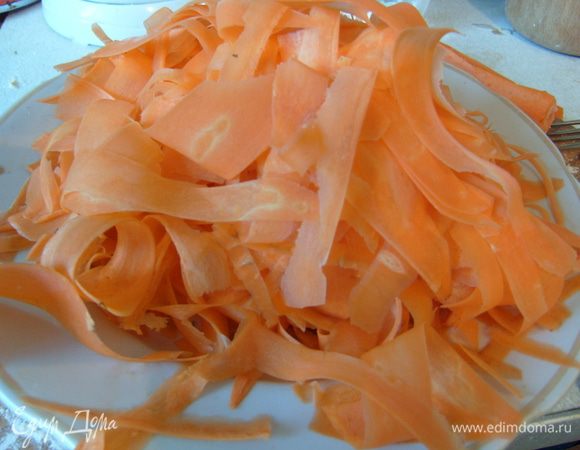 Тем временем карамелизовать сырую морковь. Для этого ее сперва очистить и при помощи овощечистки нарезать на тонкие полоски