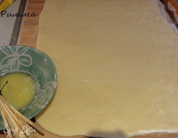 Готовое тесто раскатать в пласт толщиной 7 мм. Смазать растопленным  сливочным.
