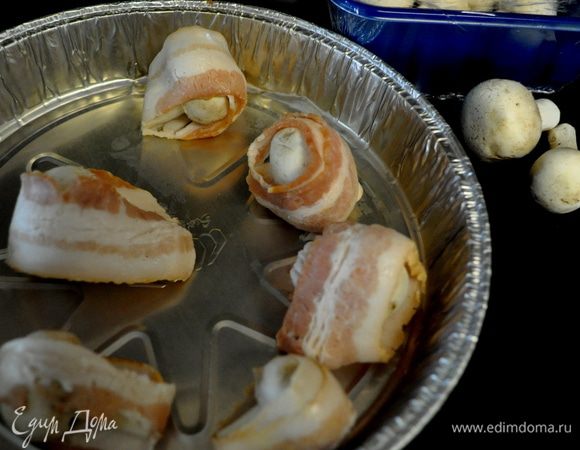 Завернуть каждый грибок в полоску бекона,можно зубочисткой закрепить.
На металлические и деревянные шампура нанизать.Обмазать каждый грибок соусом.