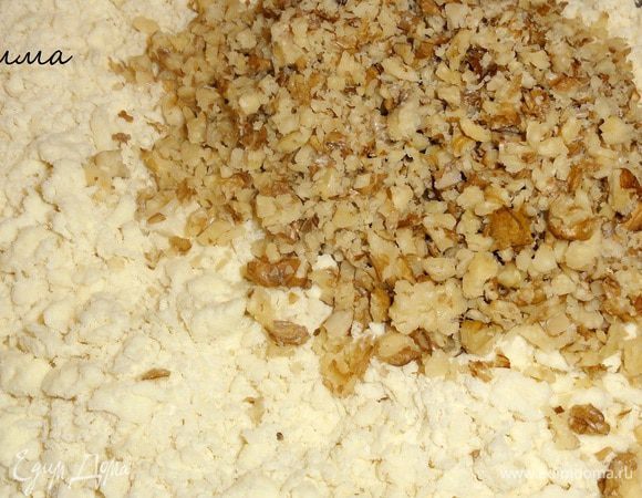 Измельчите орехи и смешайте с крошкой.