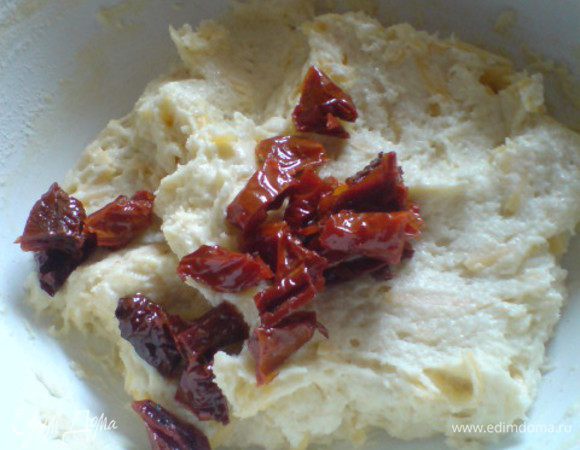 Помидоры достать,лишнее масло убрать.Нарезать небольшими кусочками.Добавить в тесто зелень и помидоры.Перемешать.