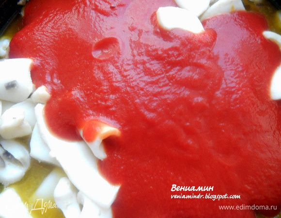 Добавить томаты, перемешать и готовить под крышкой, помешивая, на деликатном огне, 30-40 минут или до желаемой мягкости кальмаров. В процессе присолить по вкусу. 