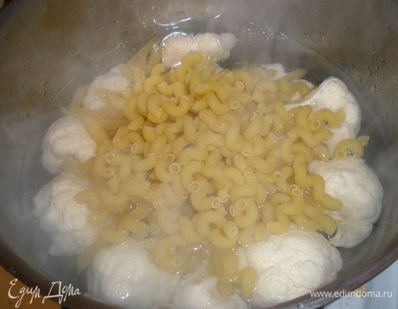 В большую кастрюлю кладем цветную капусту разделенную на соцветия и пасту, аливаем все кипятком и варим около 5-6 минут. 