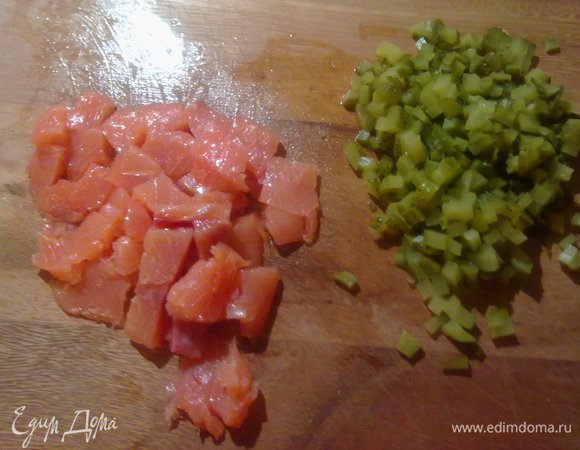 Маринованные огурчики порезать мелкими кубиками. Рыбу тонкими кусочками.