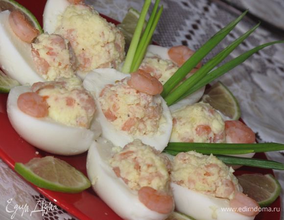 яйца отварить в крутую.
в кипящую подсоленную воду выложить замароженные креветки и проварить 2 мин,яйца разрезать вдоль,вынуть желтки,добавить в последние масло сливочное(мягкое),растительное,сок лимона или лайма,посолить,поперчить.Креветки мелко порезать и перемешать с размятыми желтками.Этой вкусной массой заполнить белки.Украсить зеленью и збрызнуть ещё лимоном!Угощайтесь, дорогие гости!