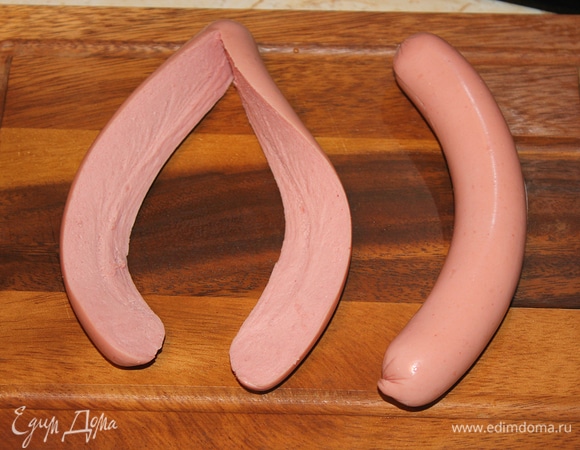 Разрезать сосиску вдоль пополам, но не до конца — оставить краешек длиной в 1,5–2 см.