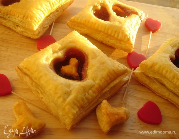 Может быть слойки-это банально,но всегда вкусно.Раскатайте пласт теста в прямоугольник,разрежьте вдоль пополам,а затем на прямоугольники.В верхней части слойки формочкой вырежьте сердечки.Выложите нижние половинки слоек на противень с пергаментом,смажьте края белком,на середину выложите начинку,накройте верхним нарядным слоем и прижмите края вилочкой.Смажьте поверхность слоек белком,можно сверху на тесто прилепить вырезанные сердечки.Засыпать сахаром и выпекать при 180-200*С до хрустящей корочки.Любите друг друга! 