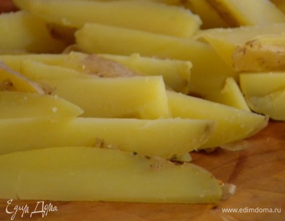 Картофель вымыть и отварить в мундире, а затем вместе с кожурой разрезать вдоль на 8 частей. 