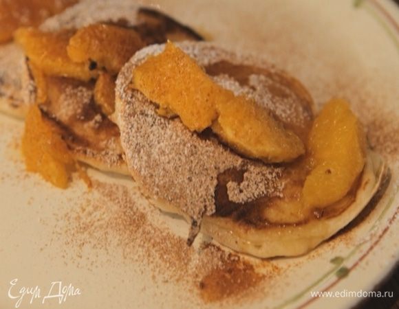 Подавать оладьи с апельсиновым соусом, посыпав их сахарной пудрой и корицей.