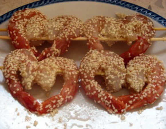 Взбить белок вилкой.
Обмакнуть креветки в белок и обвалять в семенах кунжута.
Обжарить в кипящем масле и подать с соусом.
