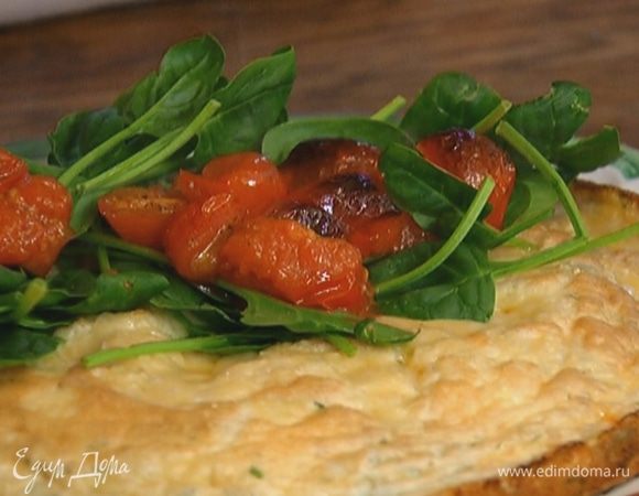 Готовый омлет переложить на тарелку, на одну половину выложить листья шпината и помидоры.