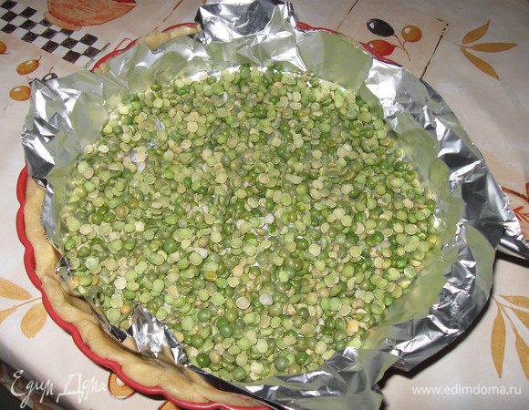 Уложить на тесто фольгу , а на фольгу насыпать 2 горсти сухого гороха.