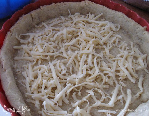 Снять фольгу, дно выпеченной основы посыпать тертым сыром.

