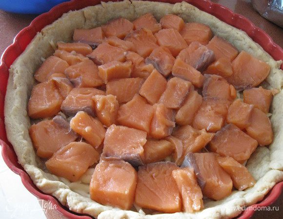 Сверху уложить ломтики рыбы, слегка(!) посолить и поперчить.