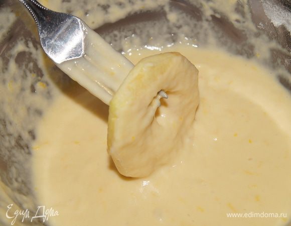 В кастрюле разогреть масло для фритюра. Каждое яблочное кольцо наколоть на вилку, обмакнуть в тесто и опустить во фритюр.