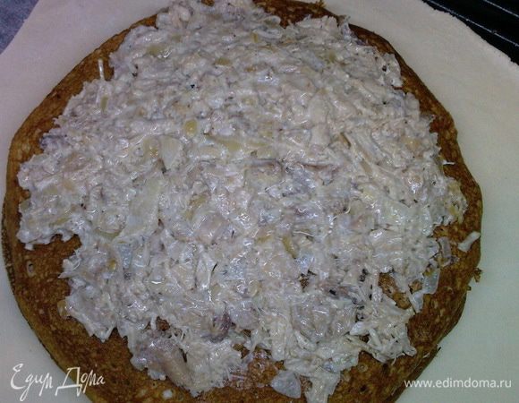 Тесто разделите на две части. Одну часть раскатайте в круг, положите два блина и на них — начинку из курицы. Накройте блином.