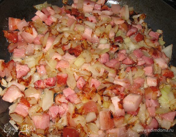 Лук обжарить на растительном масле на среднем огне при периодическом помешивании, добавить бекон к луку, жарить 5-7 мин.