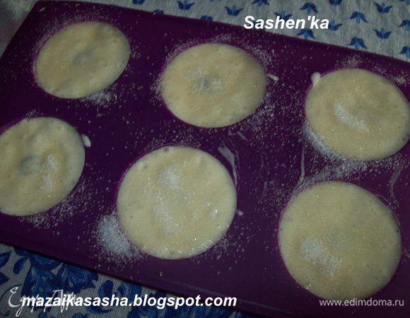 Разливаем тесто по формочкам, у меня были формочки для кексиков. Сверху присыпаем сахаром. Лучше коричневым, но у меня под рукой его не было. В середину нашей пышки можно положить ягодку или кусочек шоколада. Отправляем в духовку на 15-20 минут при температуре 170 гр. Затем (Если в вашей духовке есть такая функция)на пару минут включаем гриль, что бы сахар закоричневел. Даем не много остыть и аккуратно вытаскиваем из формочек.