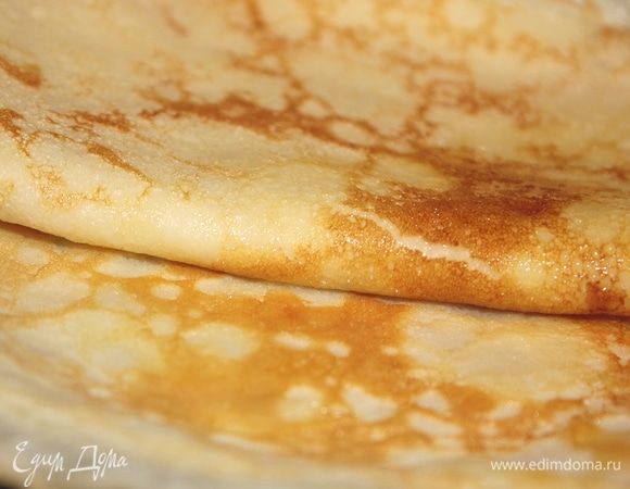 Добавить сахарную пудру. Главное не класть слишком много сахара, иначе блины будут пригорать. Добавить щепотку соли. Затем влить горячее молоко (примерно 80–90°C). Тесто для блинов получается довольно жидким. Еще я добавляю 1 или 2 столовые ложки подсолнечного масла прямо в блинное тесто.