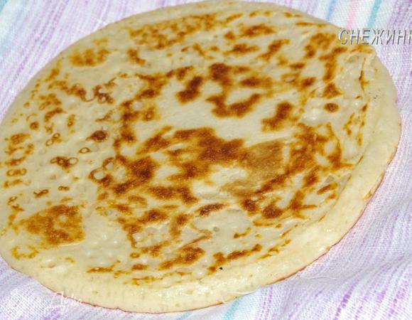 На тарелку положите одну половину кухонного полотенца, на нее — блин и накройте второй половиной до следующего блина.