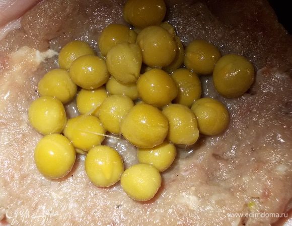 Фарш разделить на лепешечки, в каждую из которых добавить по чайной ложке горошка, лепить котлетки