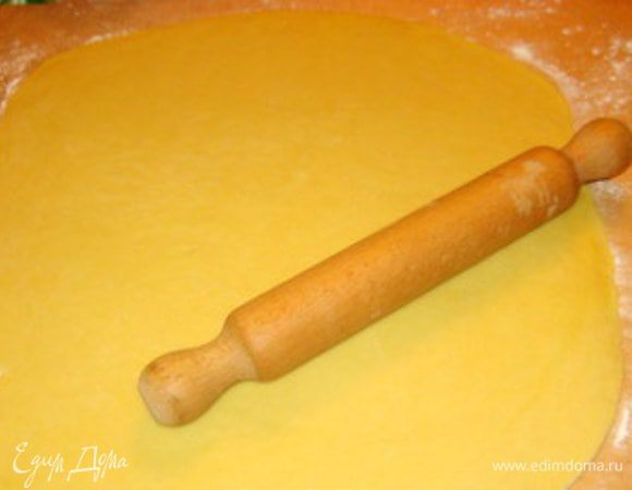 Подошедшее тесто обмять, раскатать на присыпанной мукой рабочей поверхности в пласт толщиной в 5 мм.