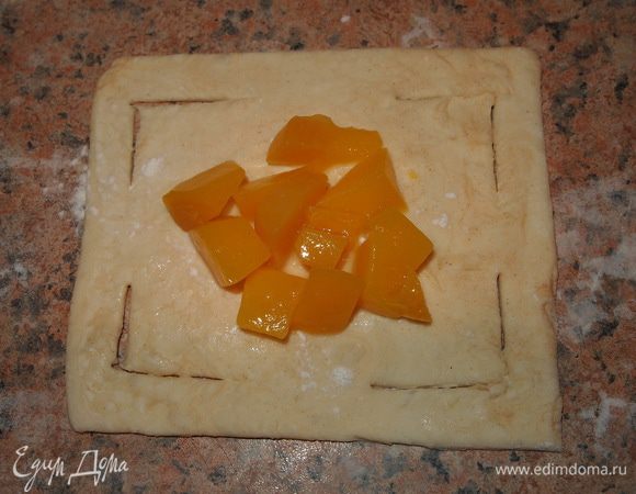 Размораживаем тесто, разрезаем на небольшие квадратики 10*10см. делаем надрезы. На центр выкладываем начинку, посыпаем корицей.