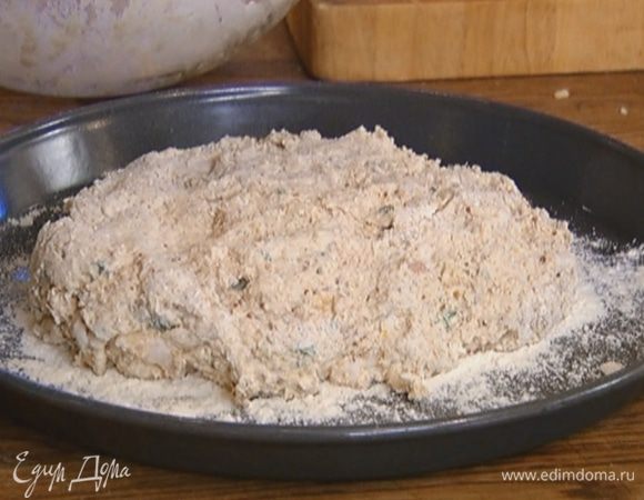 Присыпать противень мукой, выложить тесто, придав ему округлую форму (можно сделать на нем надрезы), сверху слегка присыпать его мукой.