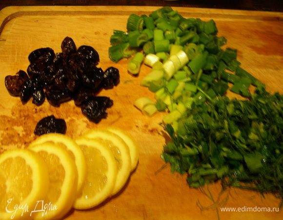 Отвариваем рис до готовности. Удаляем косточки из маслин, зелень рубим, лимон режем кружочками.
