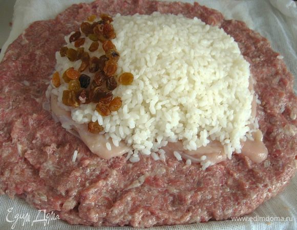 пропустить мясо баранины через мясорубку вместе с луком и чесноком.Посолить, поперчить,доб.хмели-сунели,вымесить фарш, если фарш очень крутой, добавить молока стакан.Готовый фарш выложить на приготовленную, смоченную в воде
ткань.На фарш выложить филе курицы,слегка отбитое.На филе отварной рис и изюм.