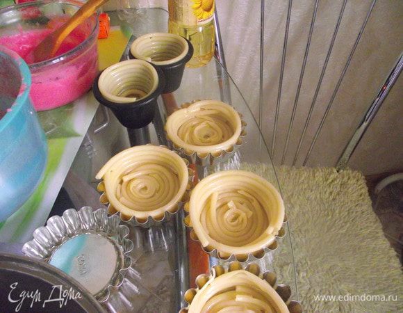 Выложить спиралью в форму для маффинов. По 6 макаронин на тарталетку примерно. На дне зазор тоже прикрыть кусочком спагетти.