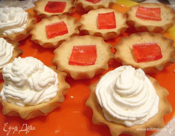 Взбить сливки и сахарную пудру. Добавить ванильный сахар. На дно корзиночки выложить кусочек мармелада и заполнить кремом с помощью кондитерского шприца.