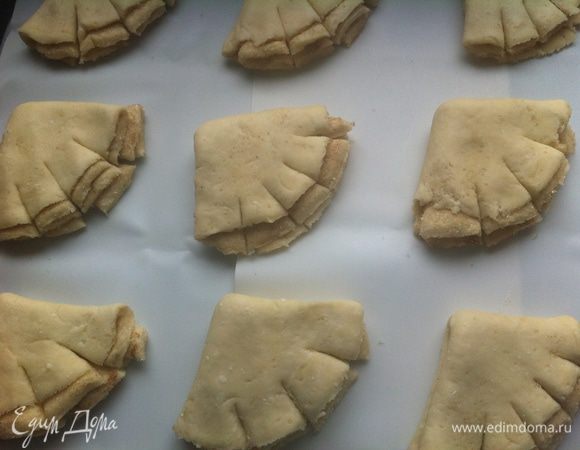 Затем каждую половинку еще раз обмакиваем в сахарную смесь и снова складываем. Получаются такие четвертинки круга. Делаем небольшие разрезики на каждом. Выкладываем на противень застеленный бумагой либо, как в моем случае, селиконовыми ковриками.