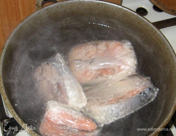 В кипящую воду опускаем как есть, прямо в пленке, рыбу, убавляем огонь и оставляем вариться.