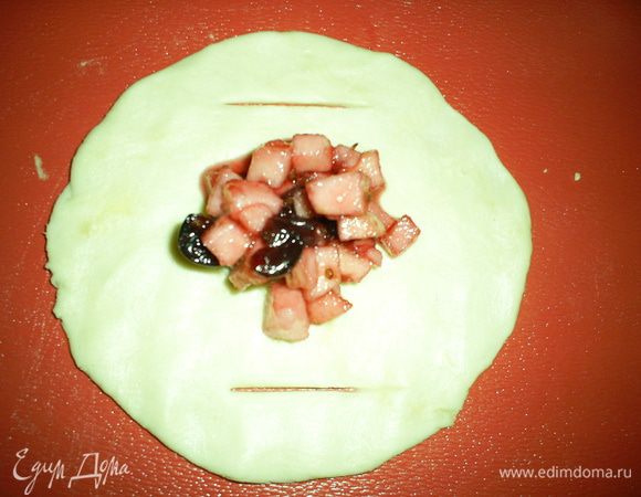 Из этого теста вы можете выпекать изделия любой формы, я же предпочитаю пирожки с открытым верхом.  Разделим тесто на 24 части, несколько оставим для работы, остальные - в холодильник, так как тесто быстро тает.
Из каждой части формируем лепешку, в центр выкладываем начинку, а по краям делаем надрезы. 