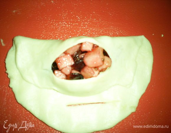 Поднимаем один край лепешки, совмещая надрез с начинкой.