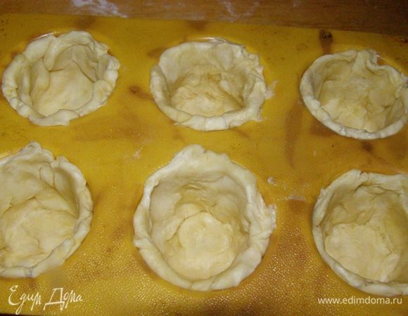 Тесто разделим на 6 кусочков. Раскатаем кружочки, выложим их в смазанные жиром формочки
