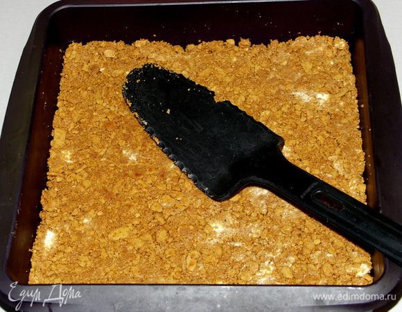 Печенье утрамбовать в силиконовую форму плоской лопаточкой в равномерный слой.Поставить форму на доску разделочную и убрать на 15-20 мин в морозилку.Духовку разогреть до 170С.