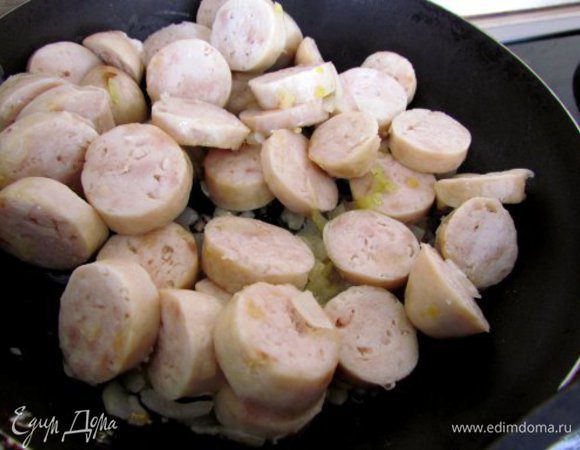 К луку добавить колбаску и слегка обжарить.