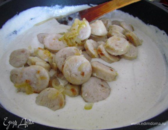 Перемешать. Дать покипеть, постоянно помешивая пару минут. Добавить колбаски с луком.