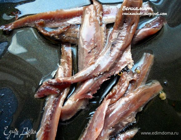 Для соуса в той же сковороде разогреть пару ложек масла, выложить анчоусы (можно бросить также зубчик чеснока). 