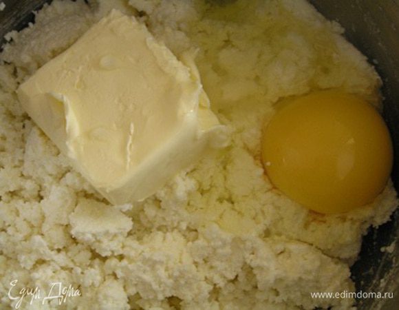 Как только сыворотка стечет, выложить еще теплую сырную массу обратно в кастрюльку. Добавить яйца, масло, соль и соду (это для пористости, но на вкус Вы её не почувствуете).