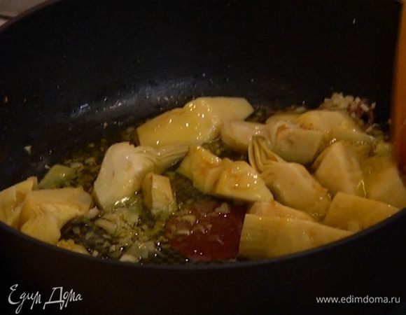 Снять сковороду с огня, добавить 1 анчоус и артишоки, все перемешать.