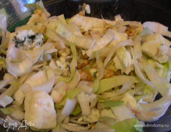 Рокфор разбираем на средние кусочки, грецкие орехи крупно рубим. Выкладываем в салатницу цикорий, рокфор, грецкие орехи и заправляем.
