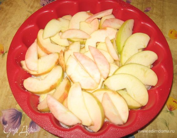 На сахар кладем яблоки, порезанные дольками.