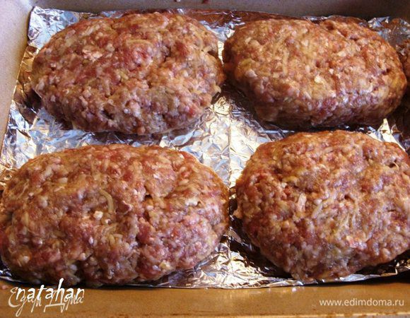 Форму для запекания выстлать алюминиевой фольгой. Из фарша сформировать 4 больших плоских котлеты.